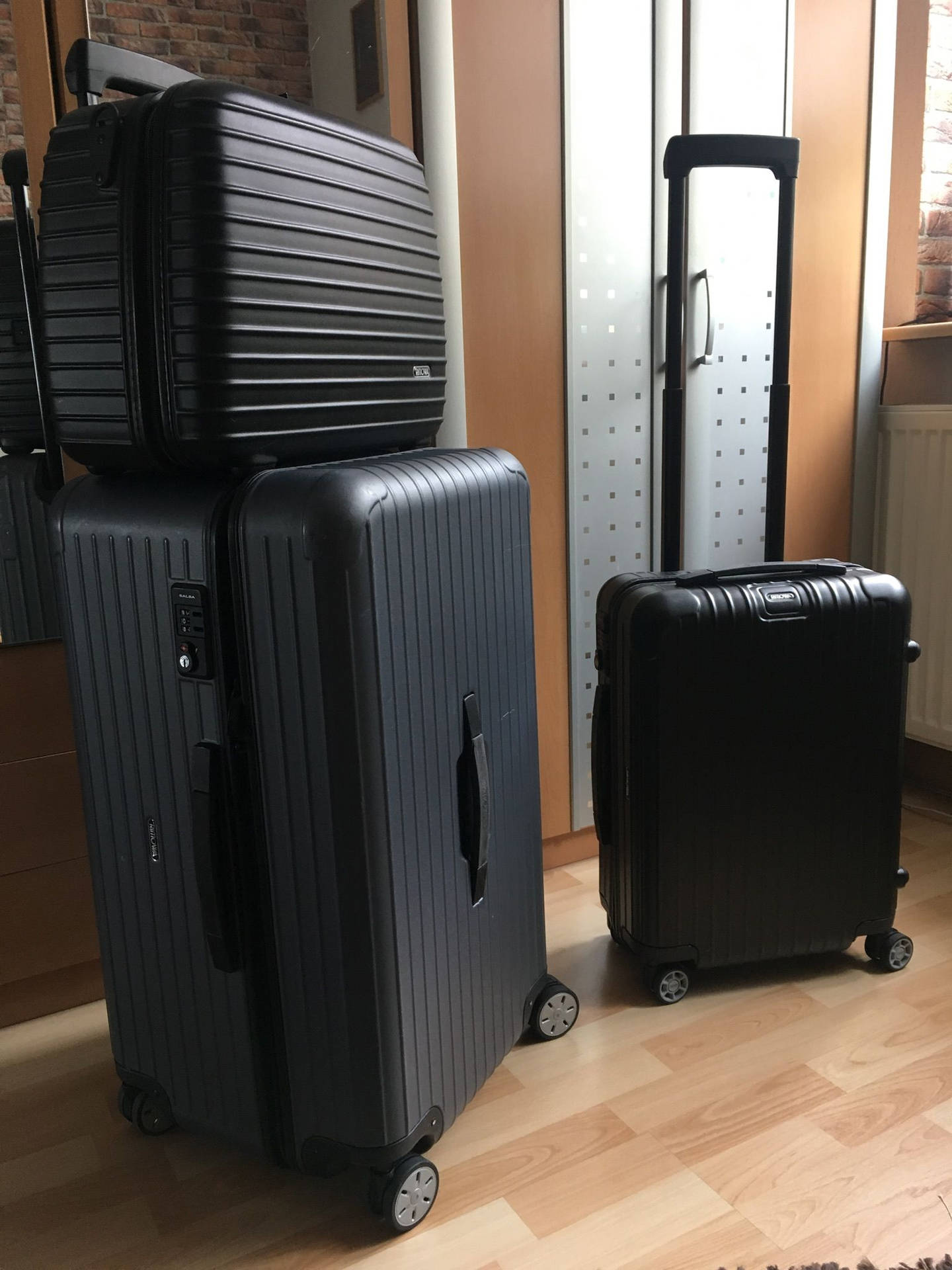 Black Rimowa Suitcases In Different Sizes Wallpaper