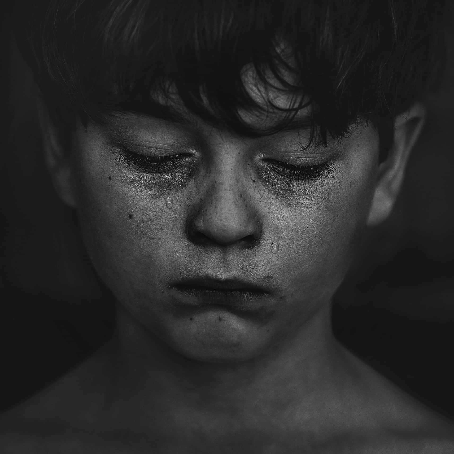 A Black And White Photo Of A Boy With Tears