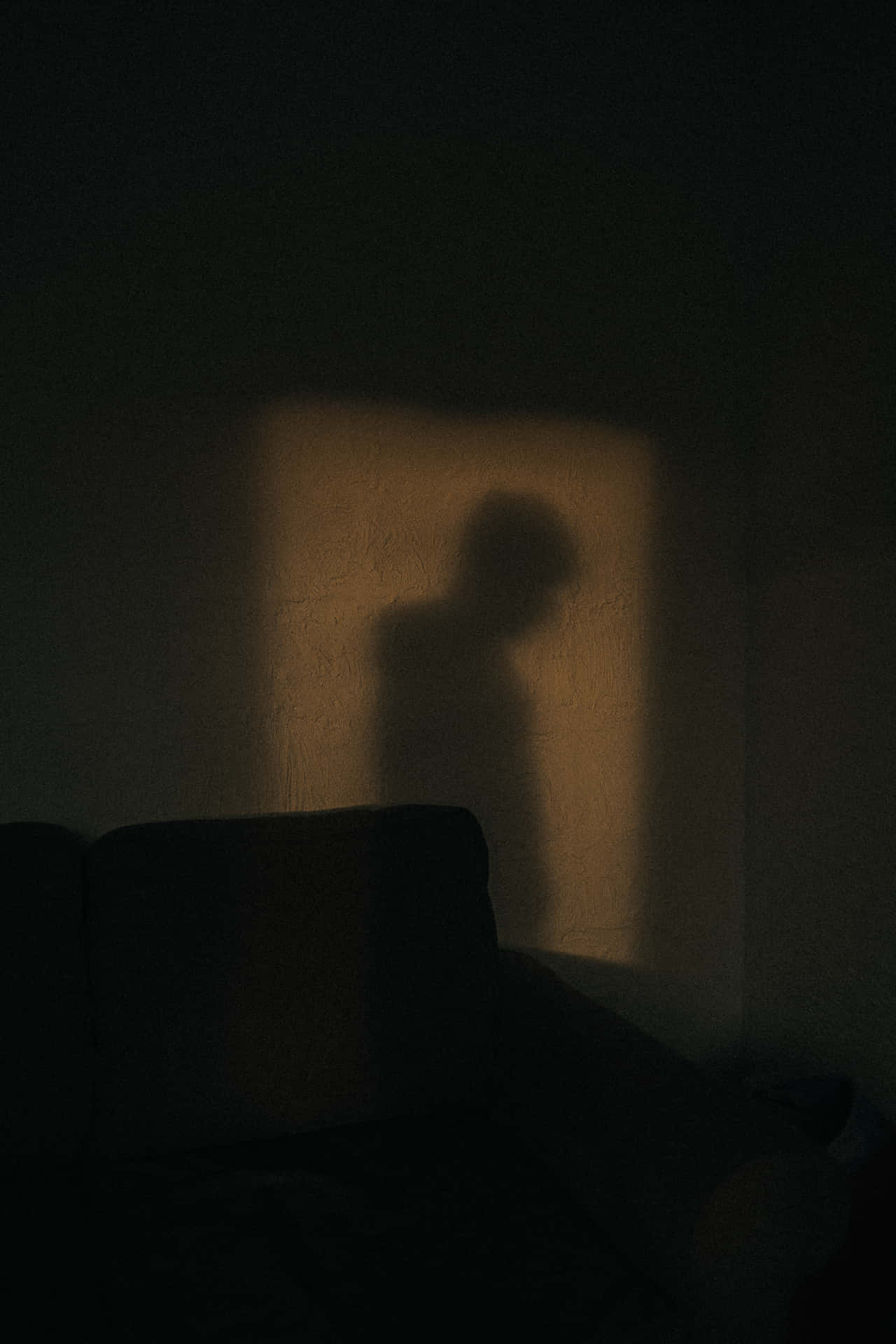 A Shadow Of A Person On A Couch