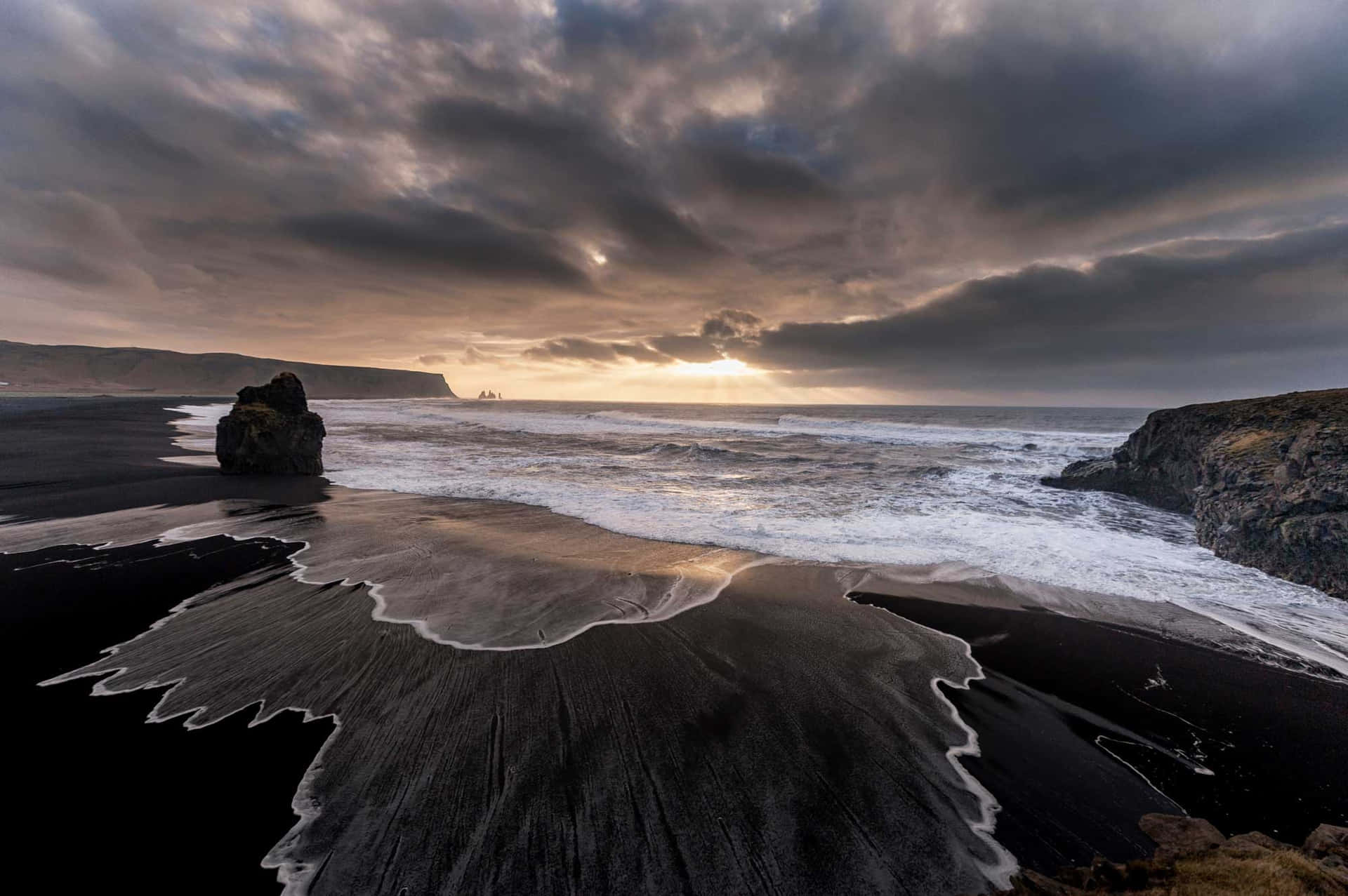 Relaxing on a Dramatic Black Sand Beach Wallpaper