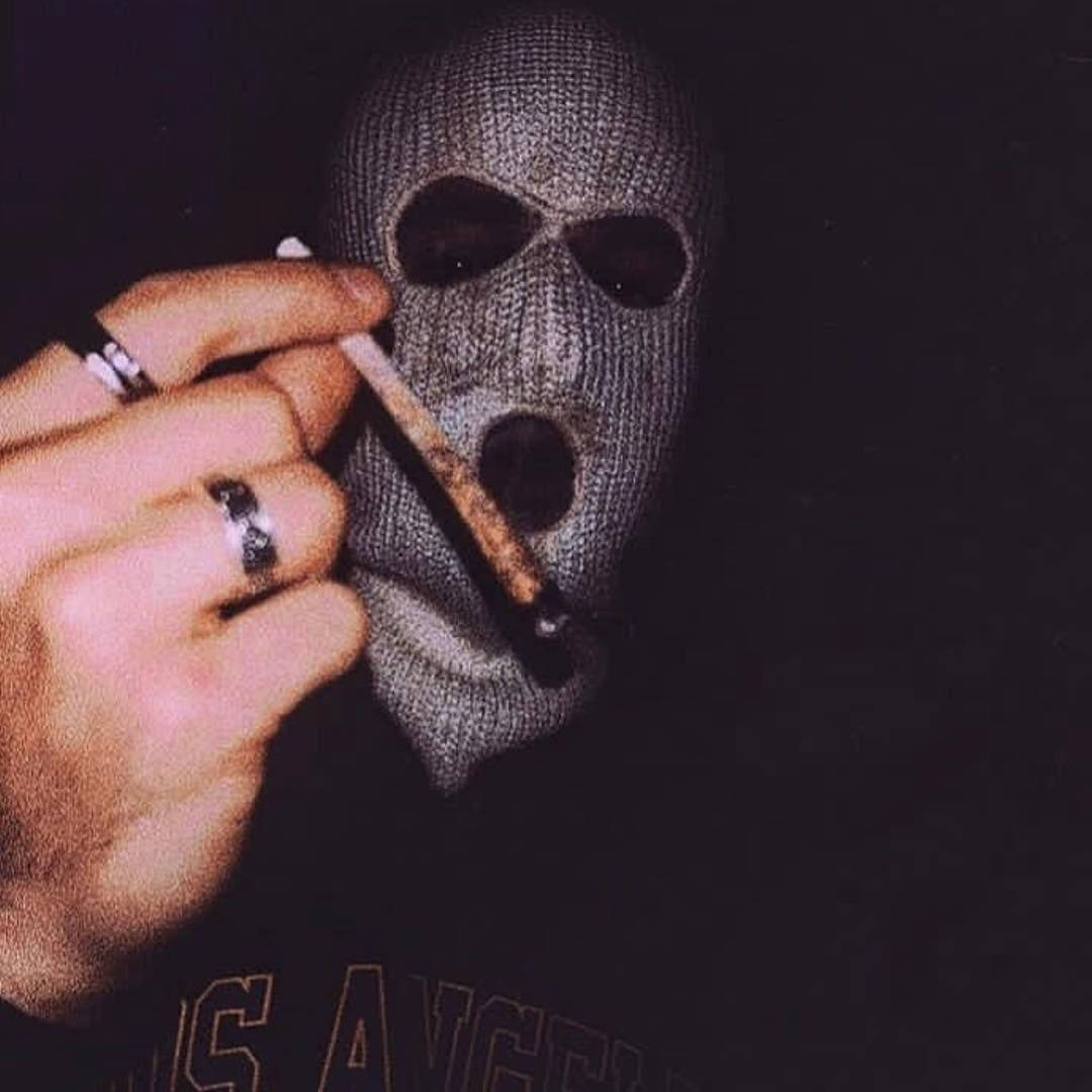Eineperson Trägt Eine Maske Und Raucht Eine Zigarette. Wallpaper