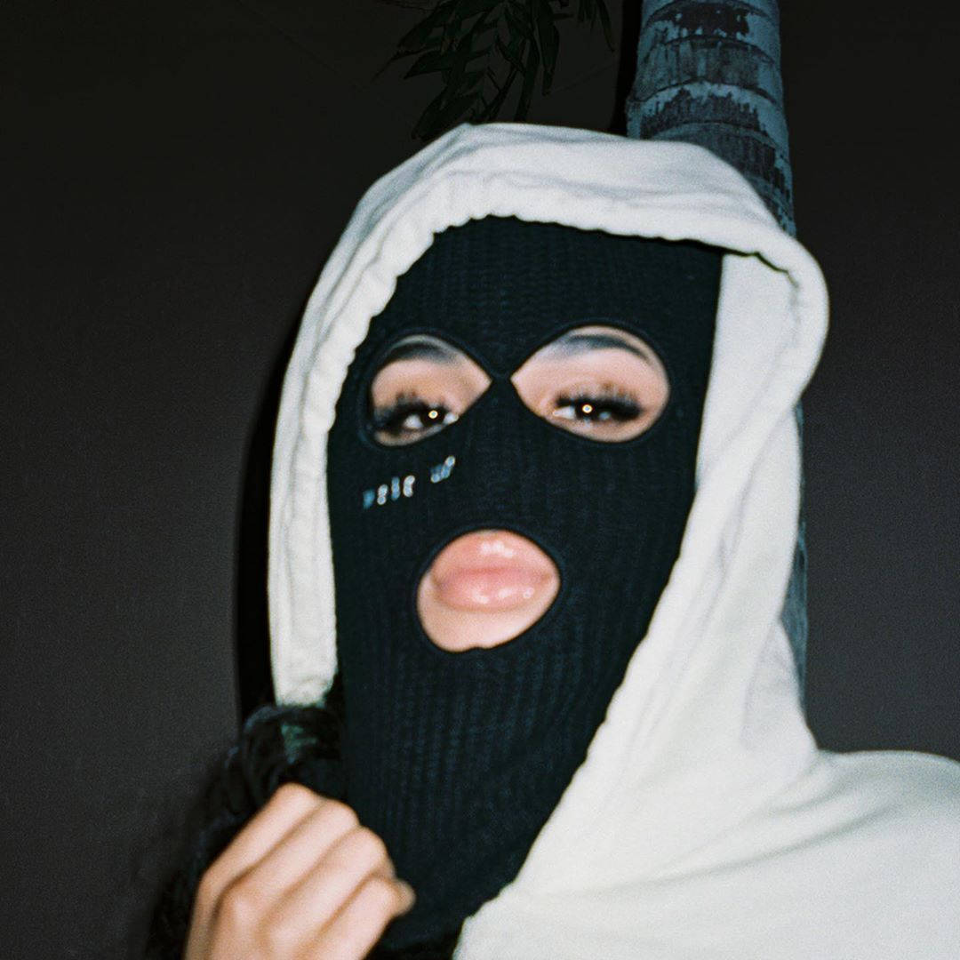 En kvinde iført en sort maske og en hættetrøje. Wallpaper