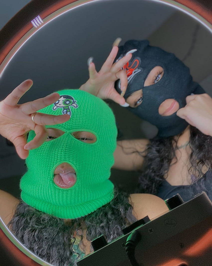 Two Women In Green Masks Posing In A Mirror Wallpaper