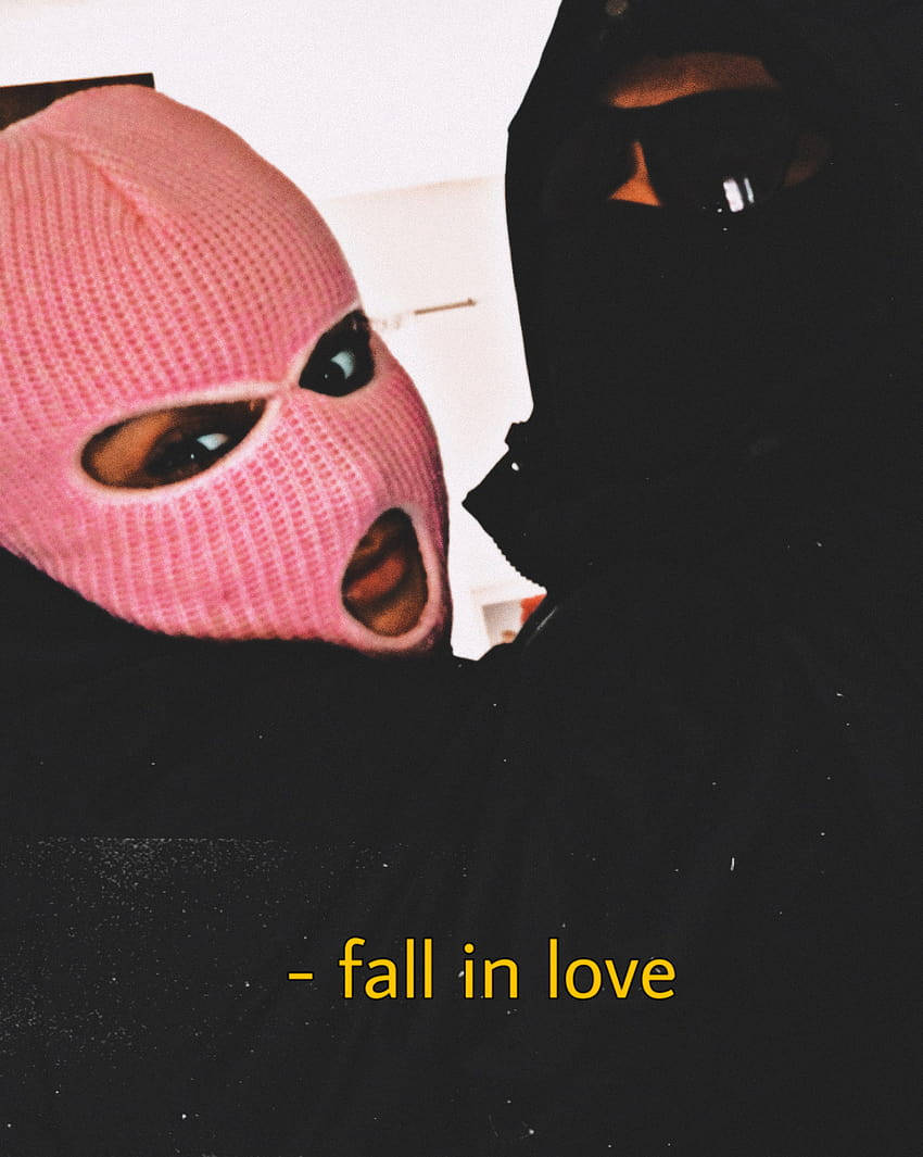 A Man And Woman In Pink Masks Holding Hands Wallpaper