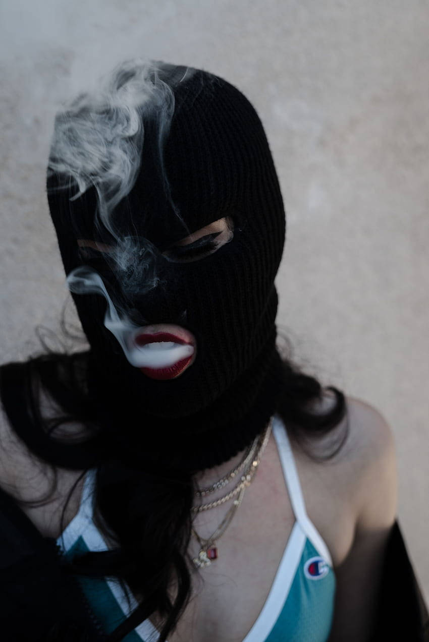 Einefrau Mit Einer Maske, Die Eine Zigarette Raucht. Wallpaper