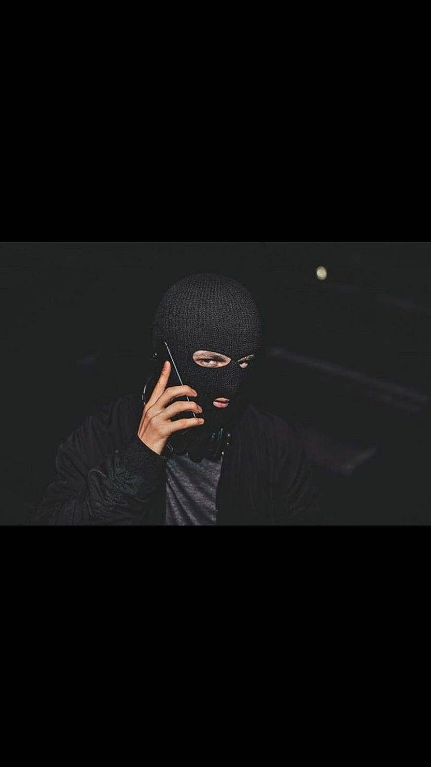 A black ski mask obscures the identity of the wearer. Wallpaper