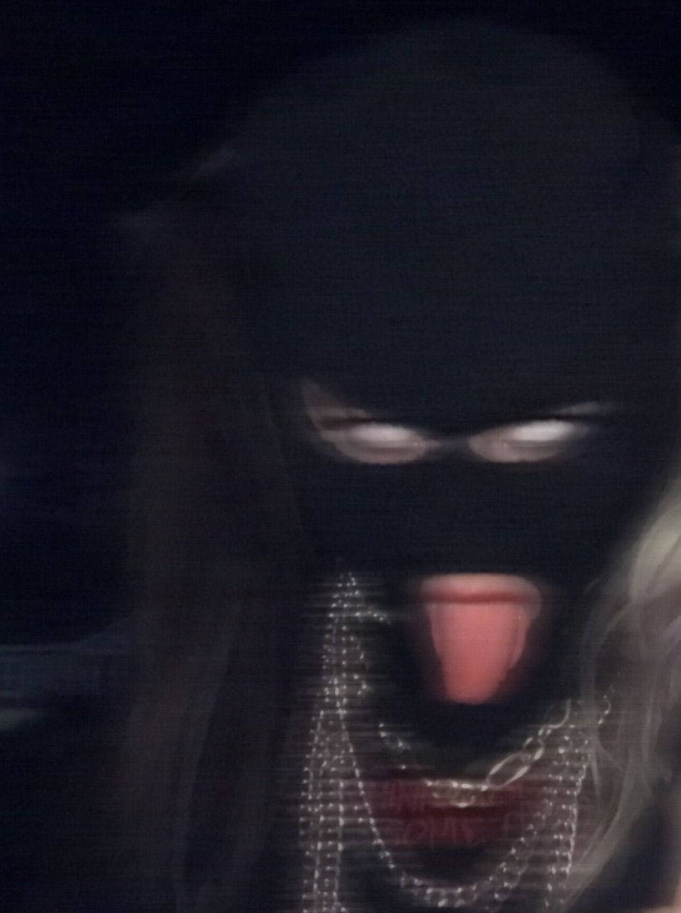 En kvinde i en sort maske med sin tunge ud Wallpaper