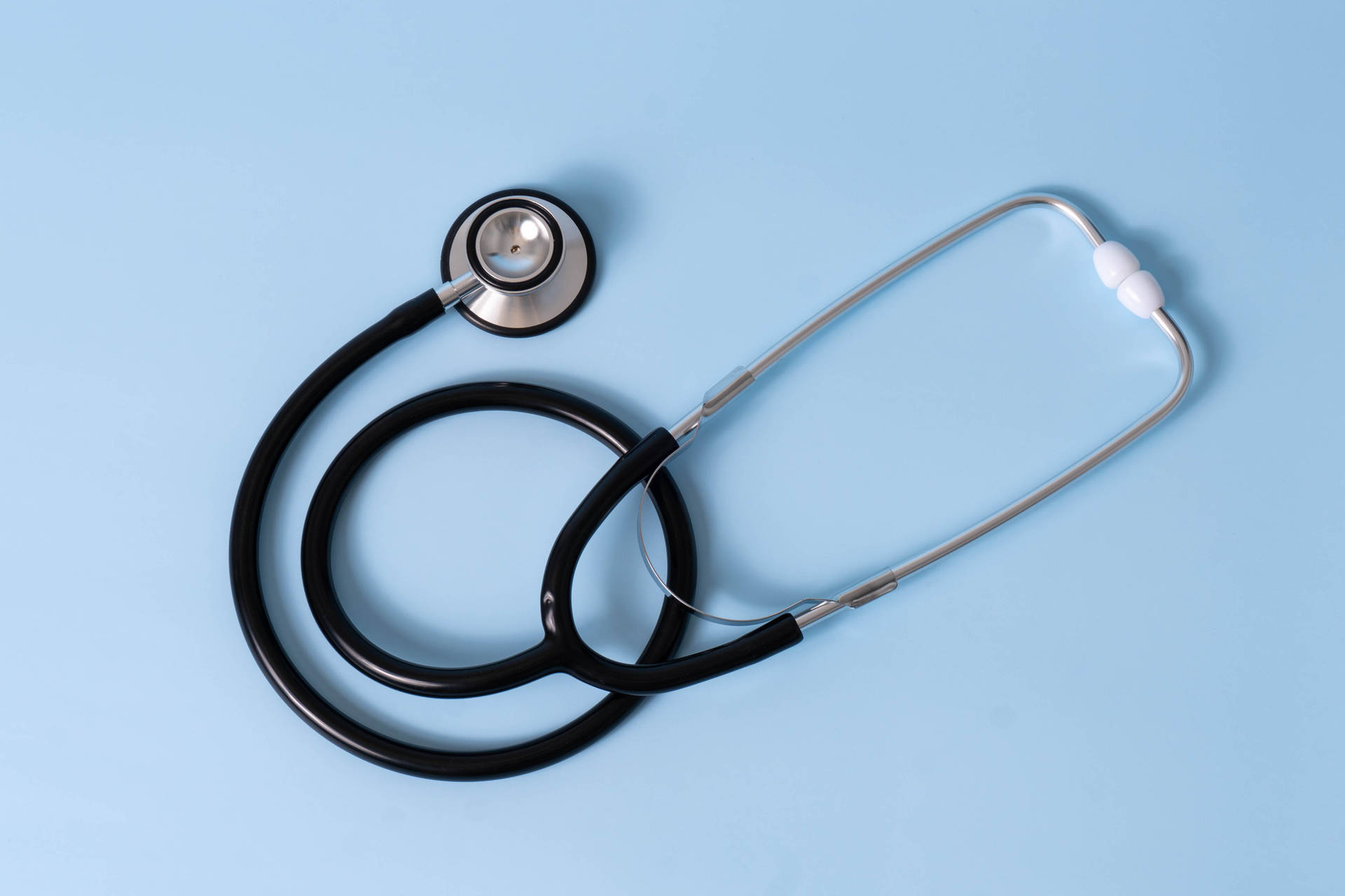 Black Stethoscope On A Blue Surface Wallpaper