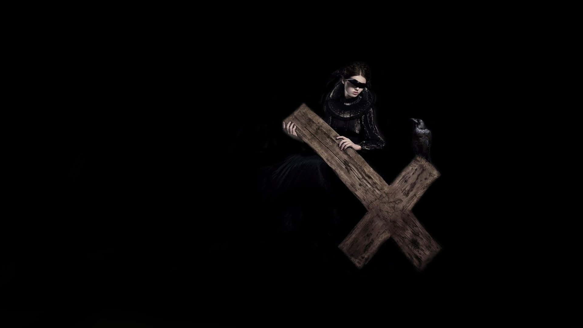 A Woman In Black Holding A Wooden Cross