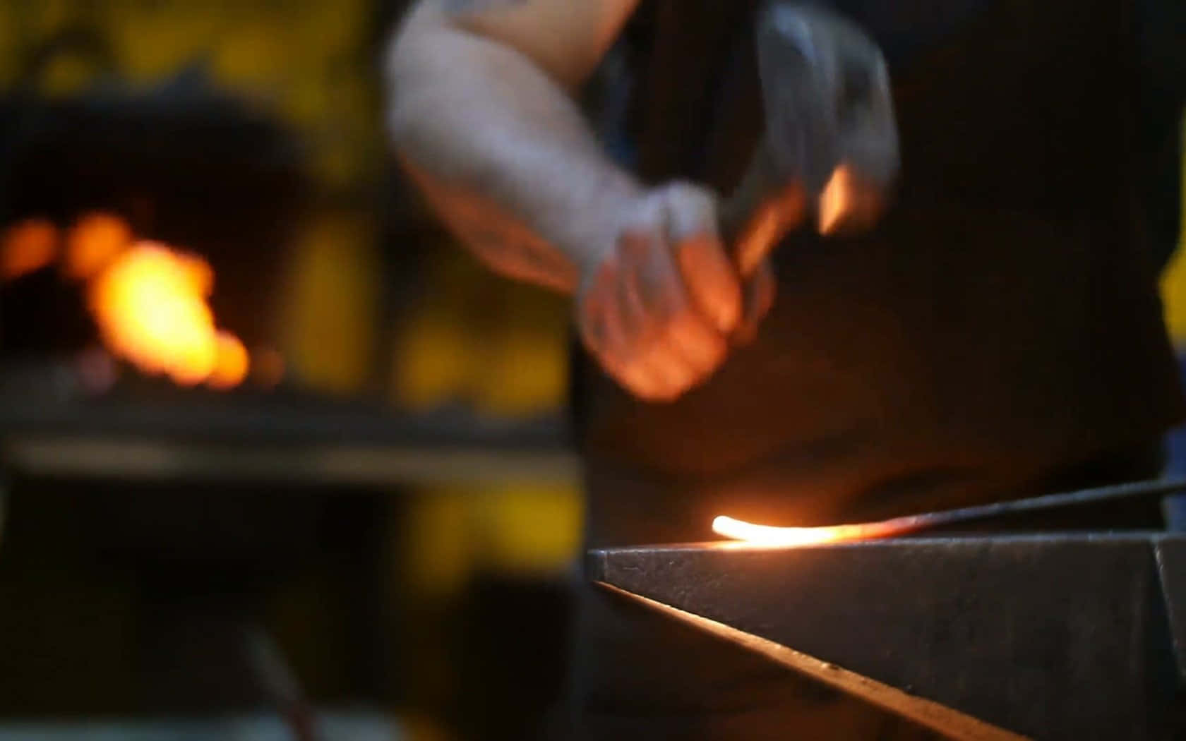 A skilled blacksmith labours in a traditional forge Wallpaper