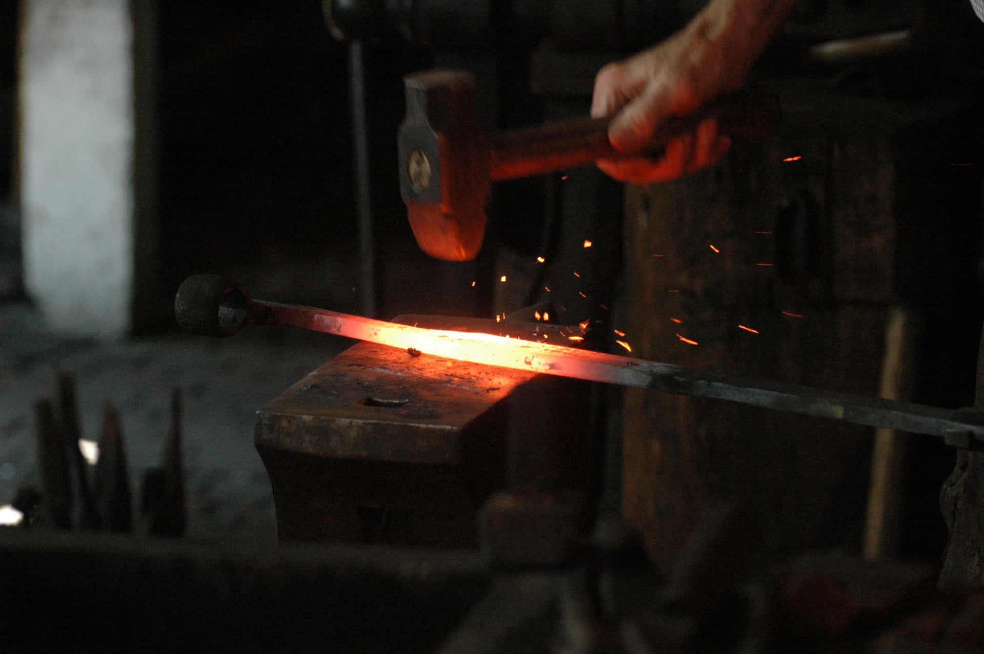 A Blacksmith laboring at the forge Wallpaper