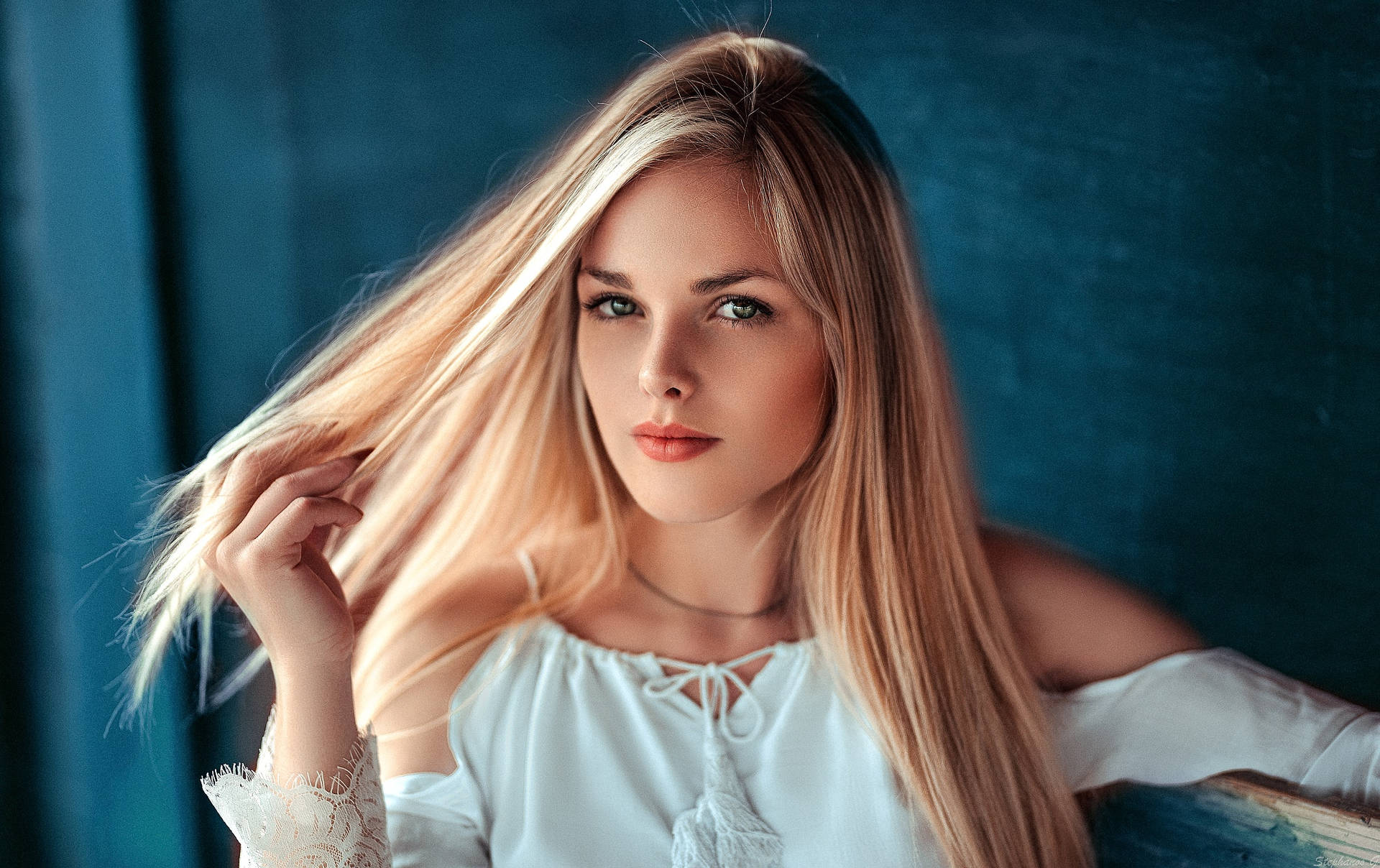 Kvindelig model med blond hår og blå øjne på baggrund af himmel tapet. Wallpaper