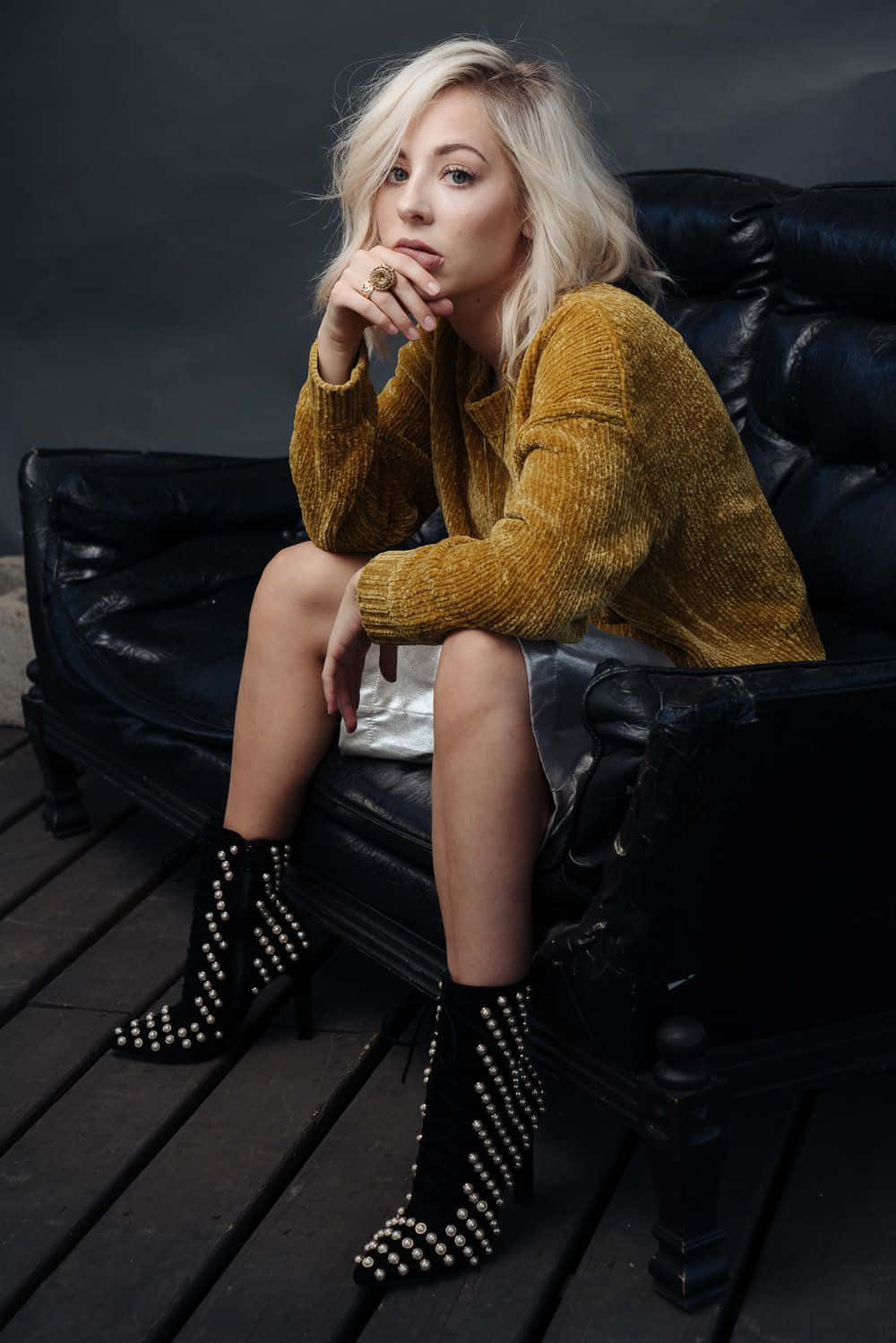 Blonde Womanin Mustard Sweaterand Studded Boots Wallpaper