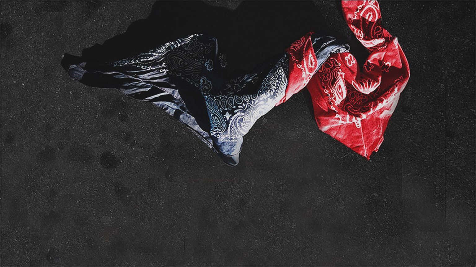 En sort og rød scarf hænger på jorden. Wallpaper