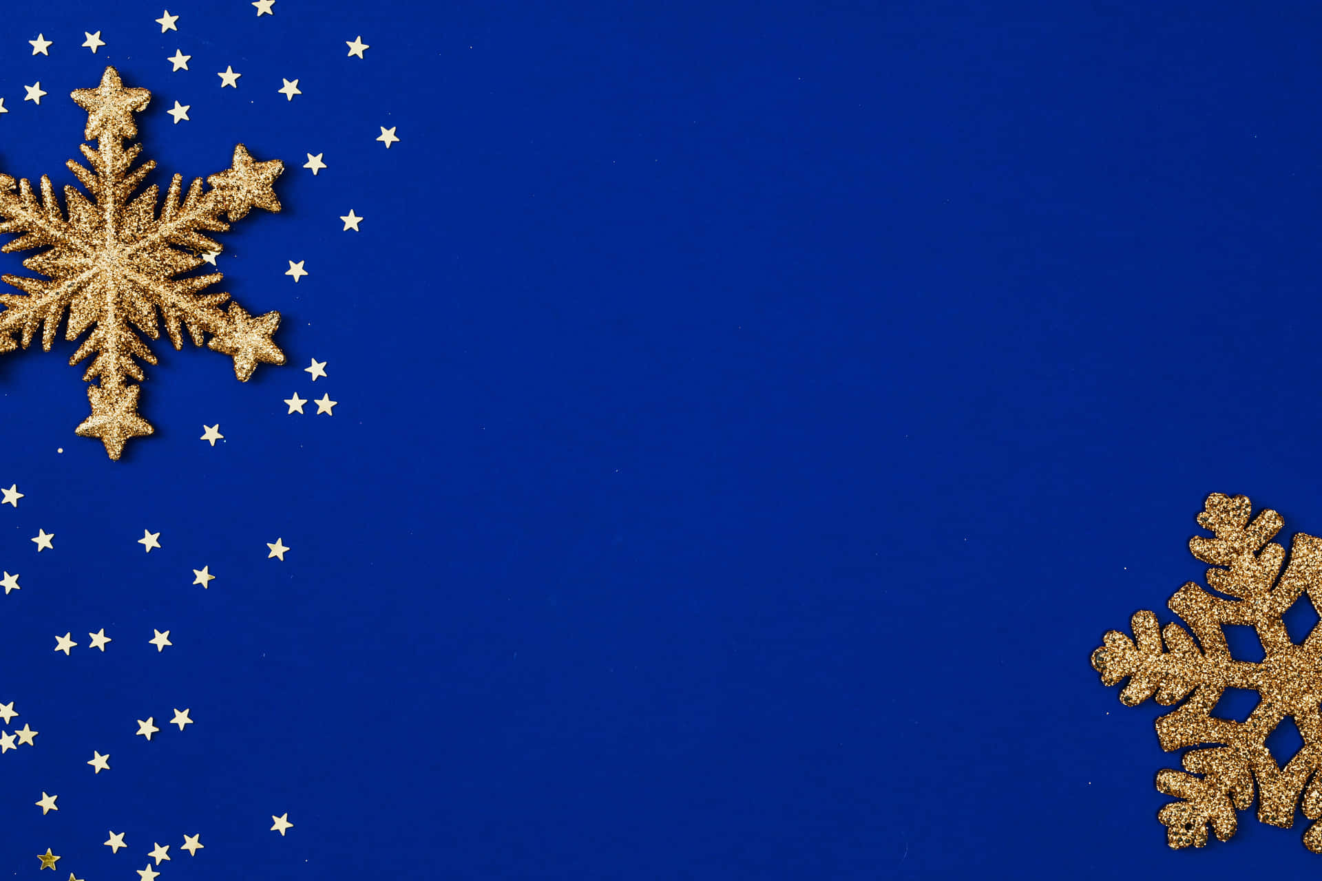 A Blue Background With Gold Snowflakes