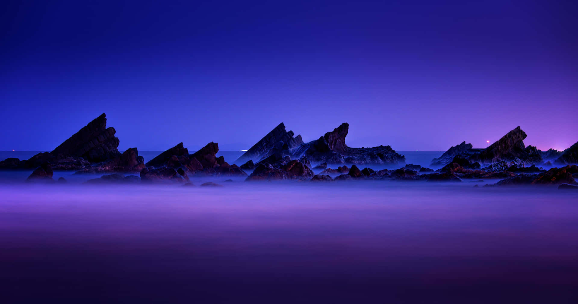 Blue And Purple Sunset With Rock Silhouettes Wallpaper