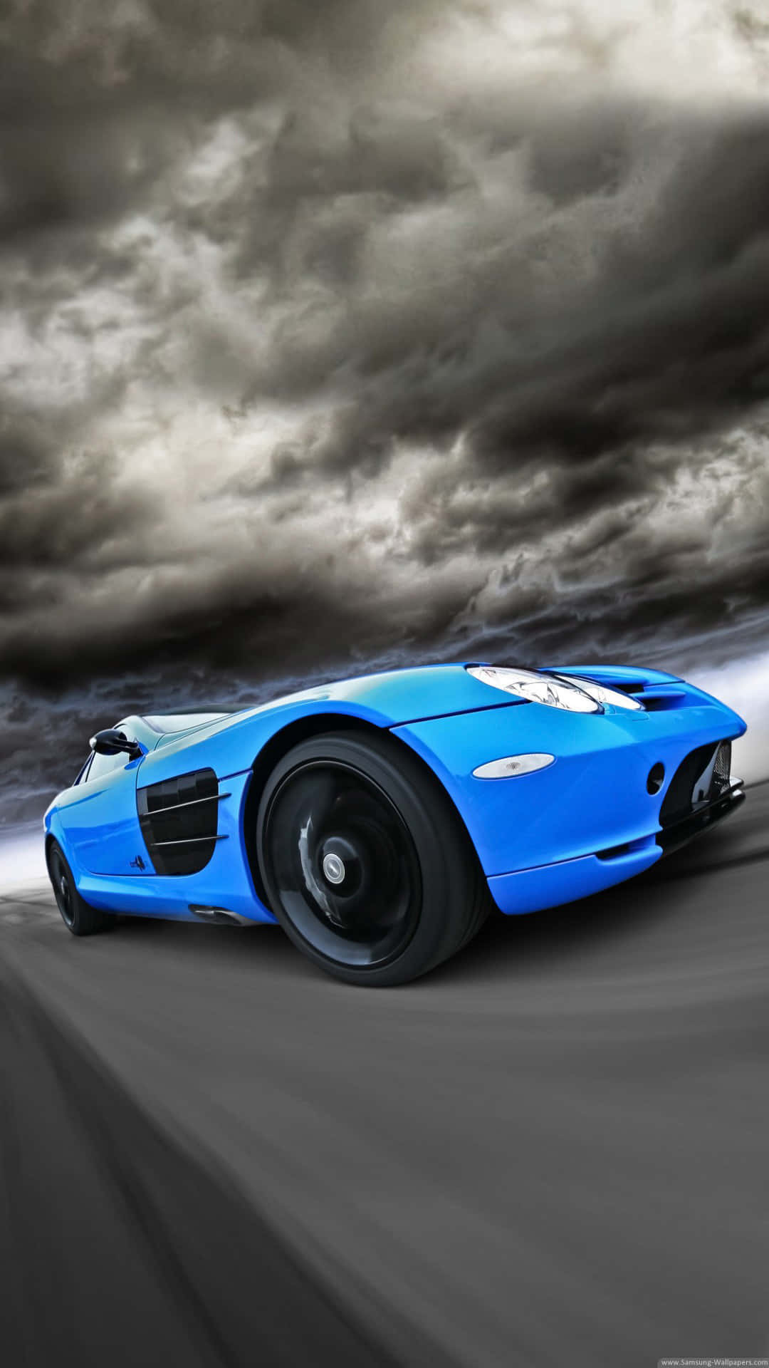 A Blue Sports Car Driving On A Road Wallpaper