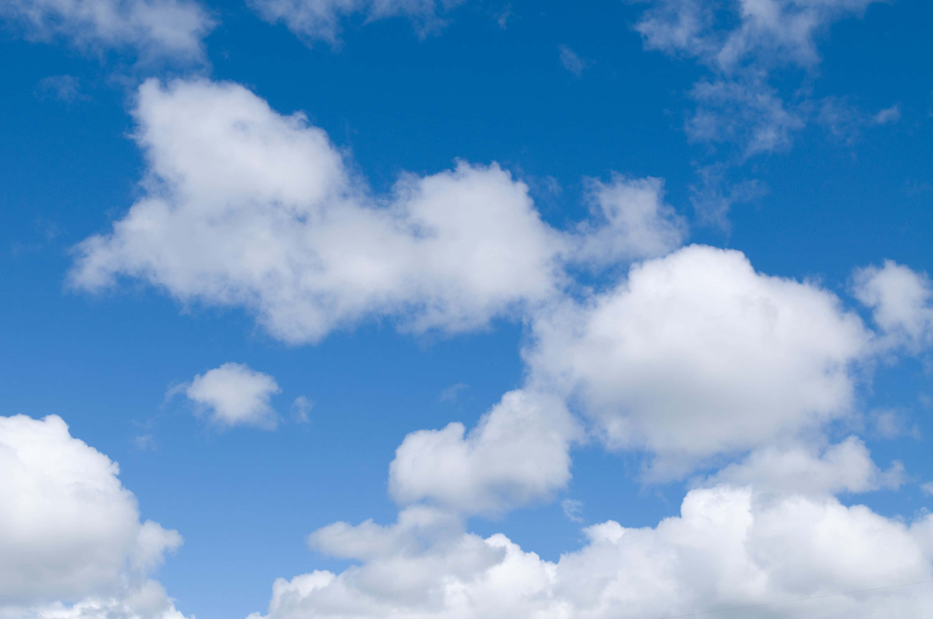 Unavista De Nubes Azules Exuberantes En El Cielo Que Forman Un Impresionante Telón De Fondo.