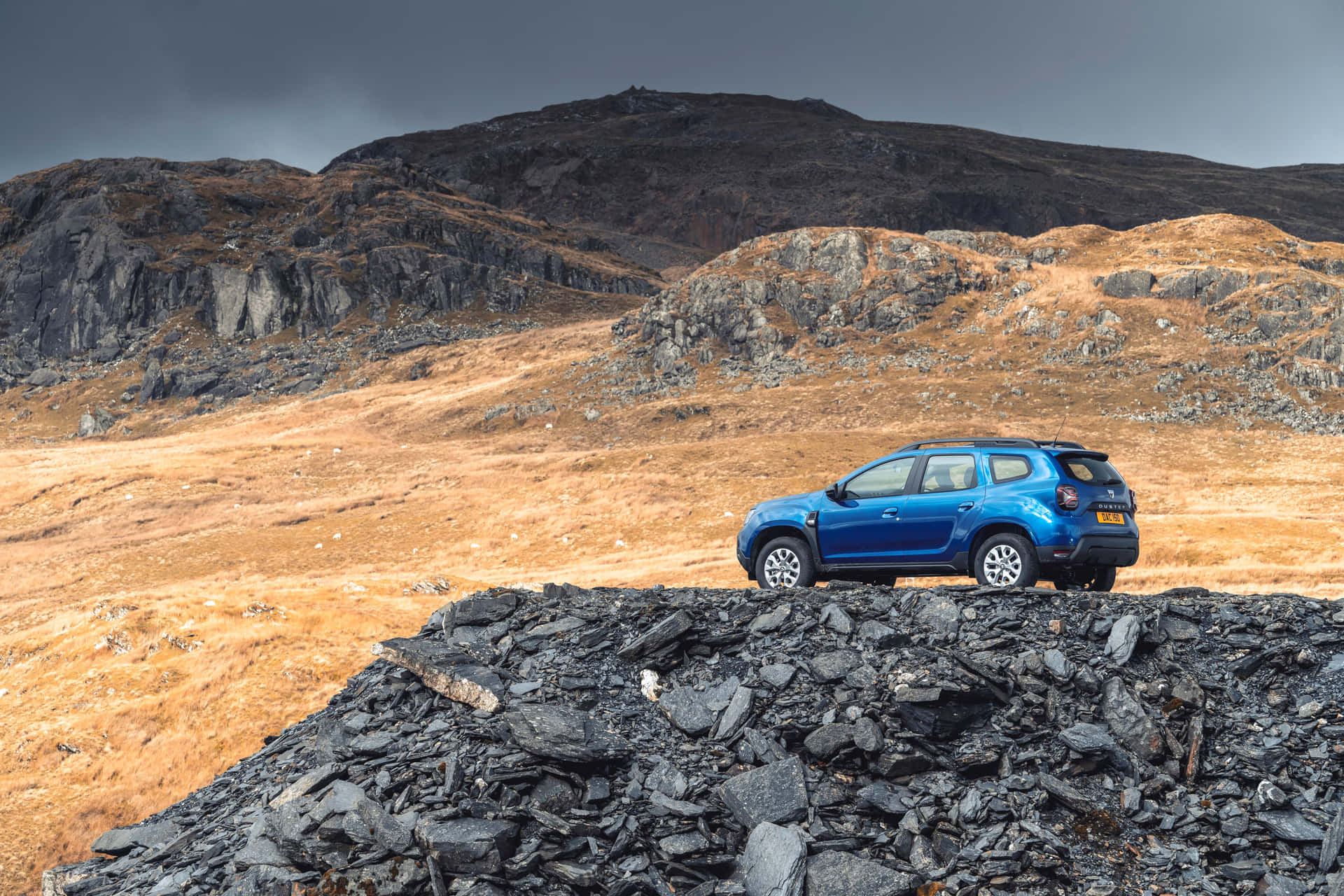 Blauwe Dacia Duster Bergachtig Terrein Achtergrond