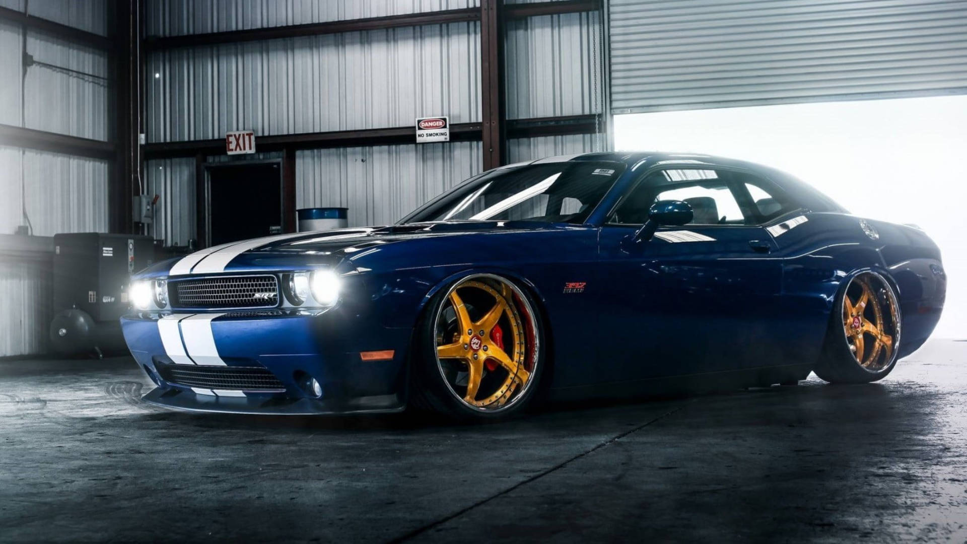 Caption: Stunning Blue Dodge Challenger Parked in Garage Wallpaper