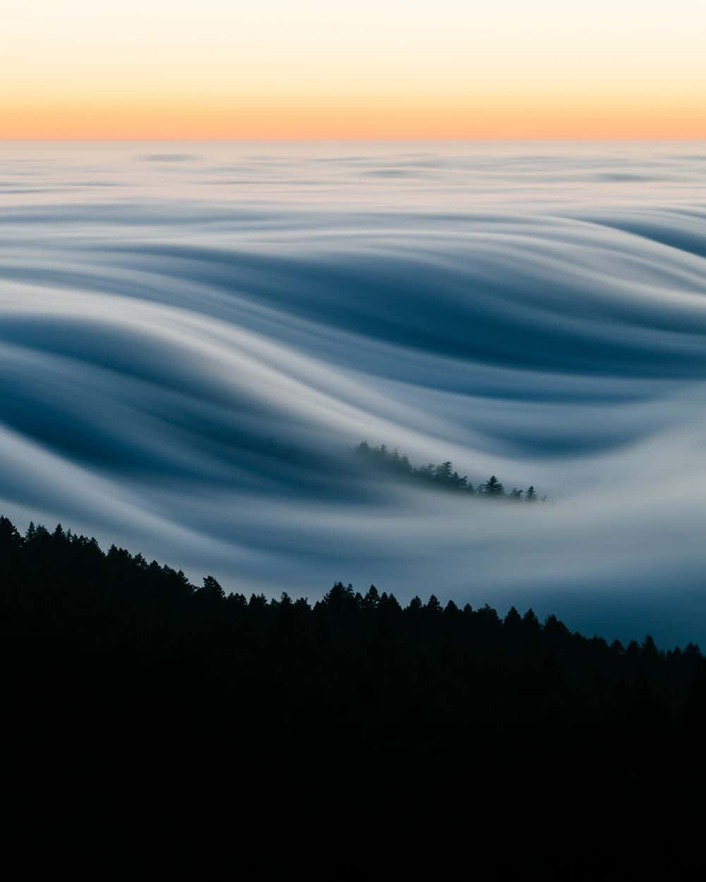 Fog Over A Mountain Range At Sunrise Wallpaper