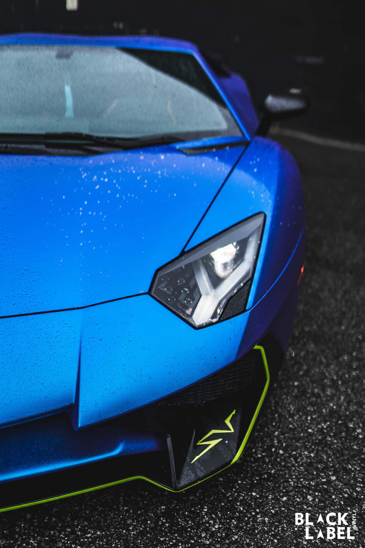 Download A Blue Sports Car Is Parked In The Rain Wallpaper 