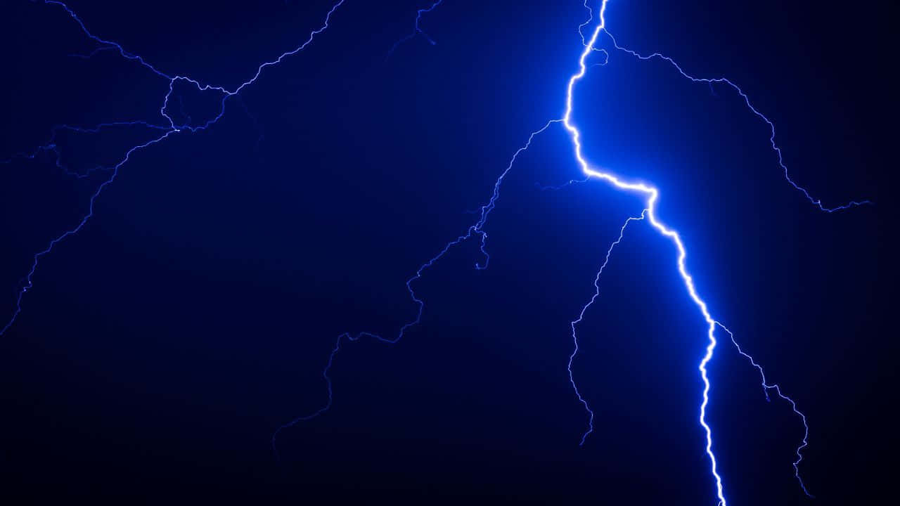 Striking blue lightning against a grey sky Wallpaper
