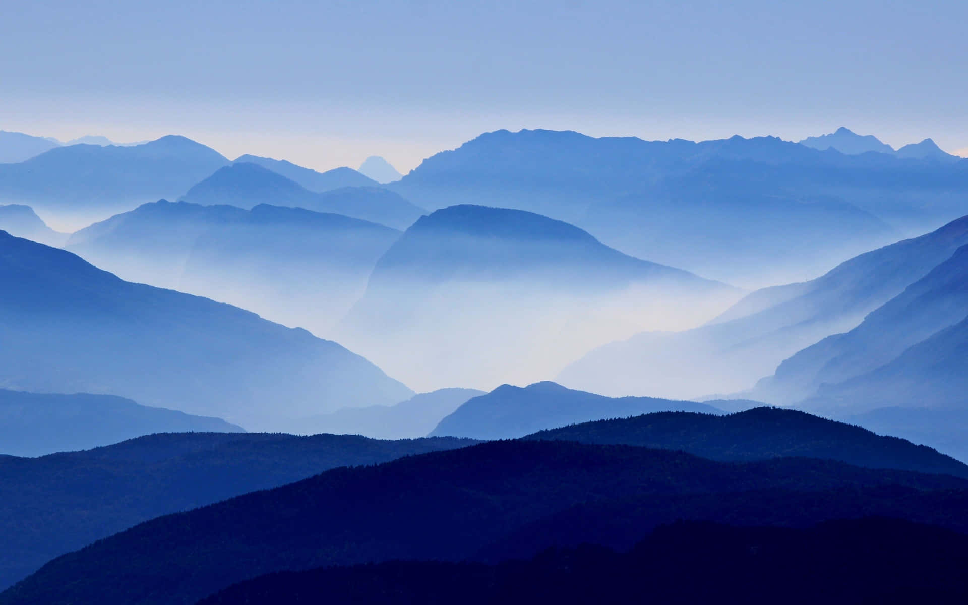 Et bjergområde med meget tåge bredt ud over det Wallpaper