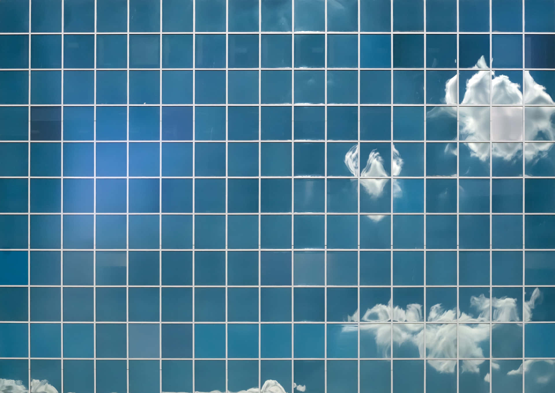 A Blue Tiled Wall With Clouds And Blue Sky