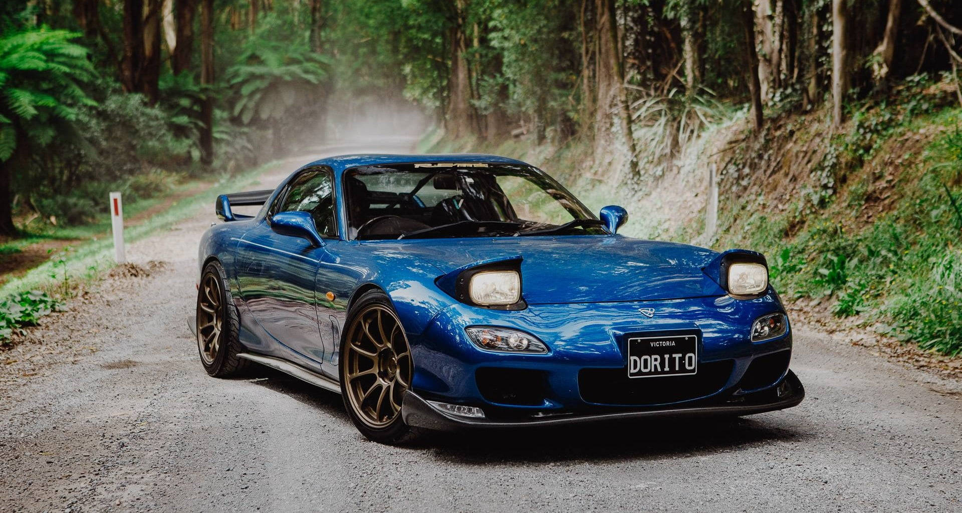 Blue Sports Car Forest Road Wallpaper
