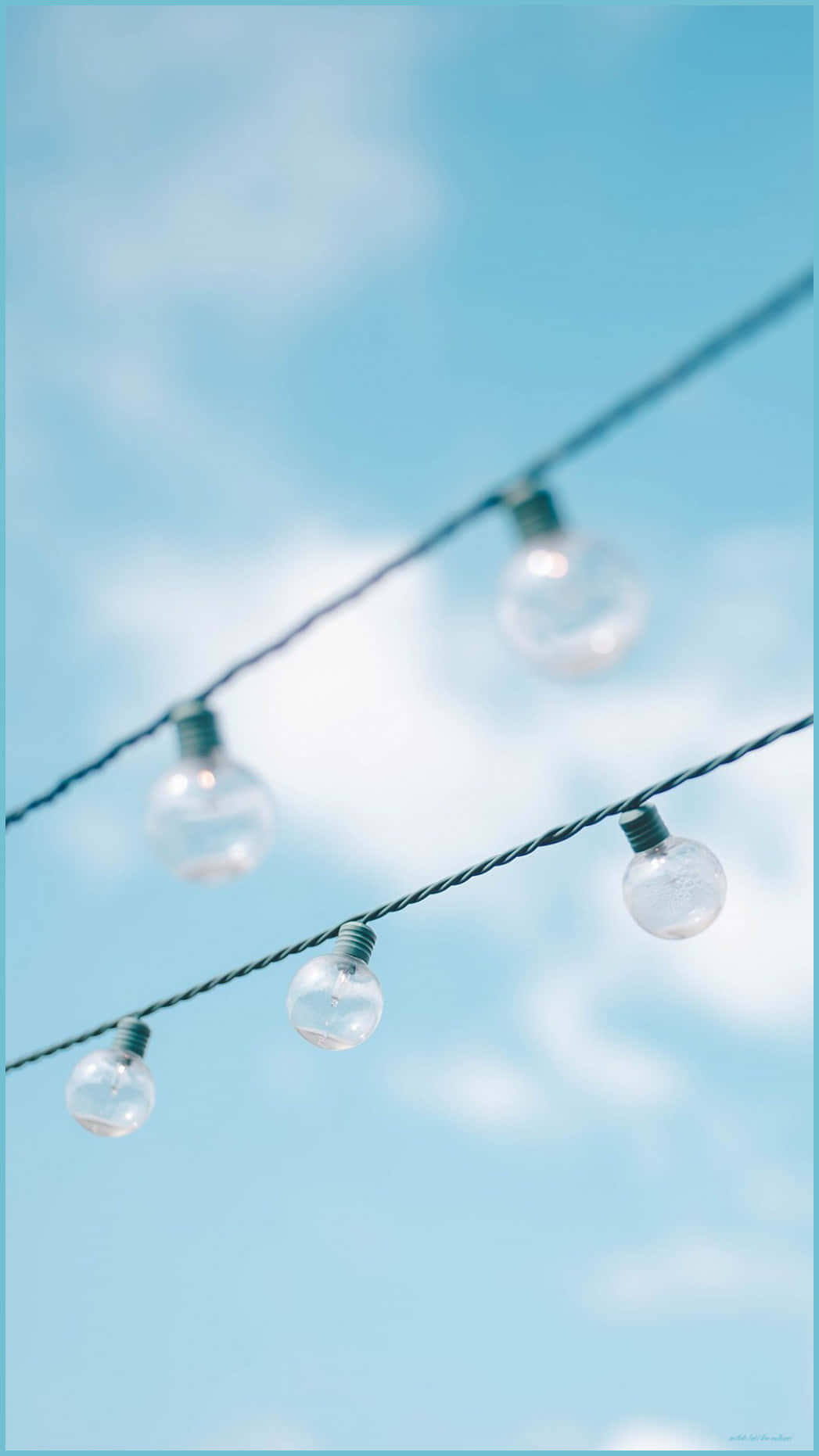 A String Of Lights With Blue Sky Behind Them Wallpaper