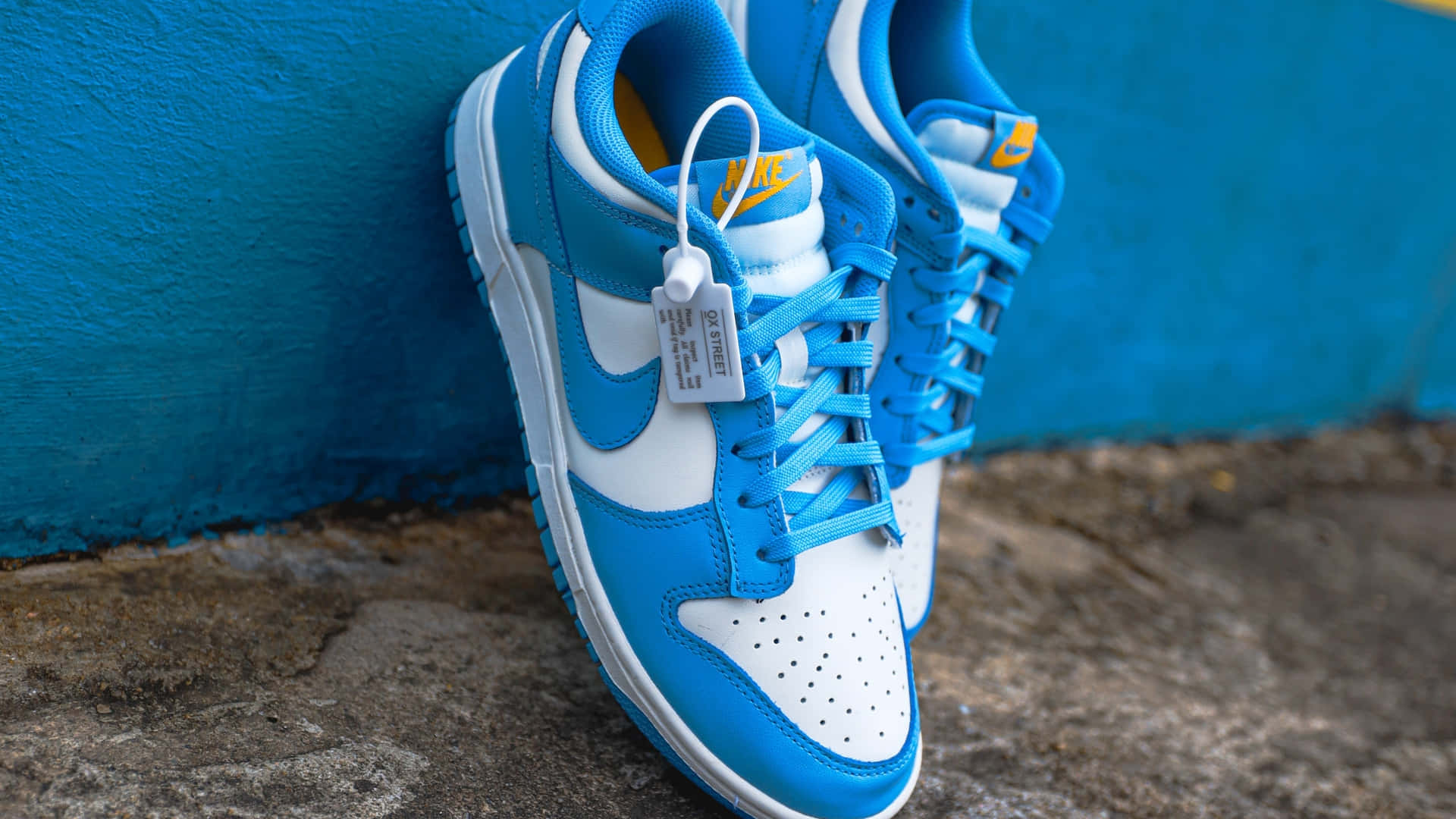Blueand White Sneakers Against Blue Wall Wallpaper