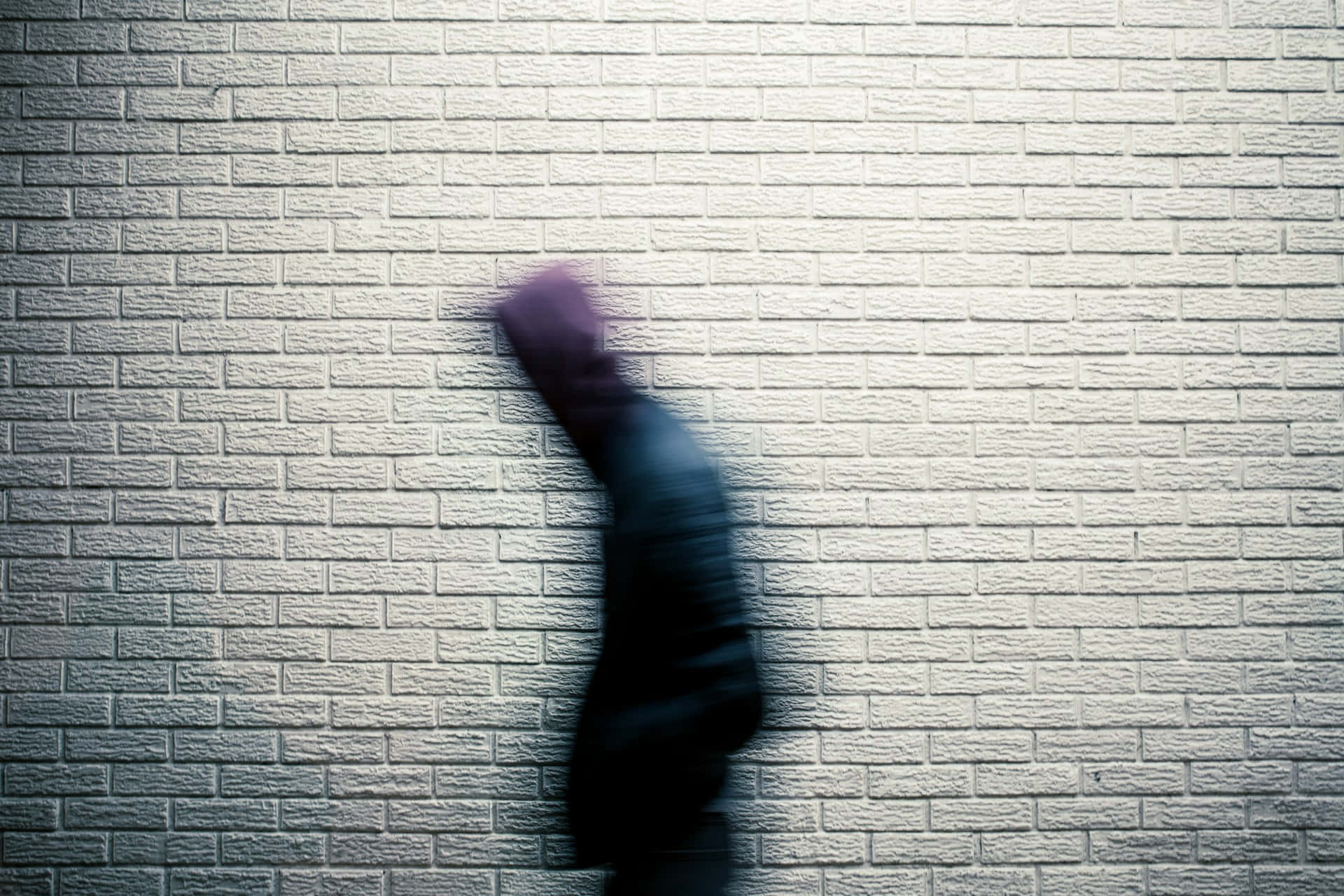 Blurry Figure Against Brick Wall Wallpaper