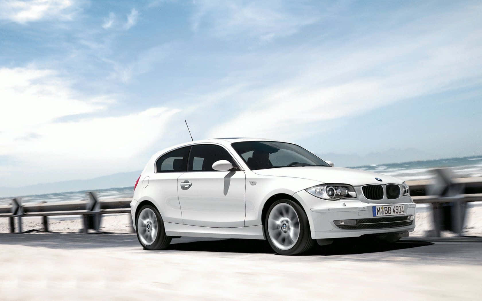 Sleek and Stylish BMW 1 Series on Open Road Wallpaper