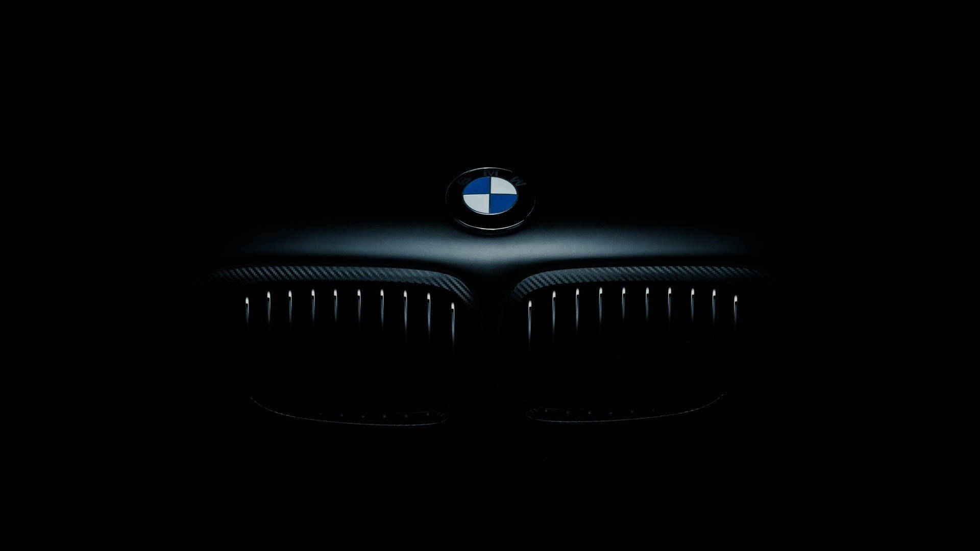 A sleek, black BMW on display in a clean, modern setting. Wallpaper