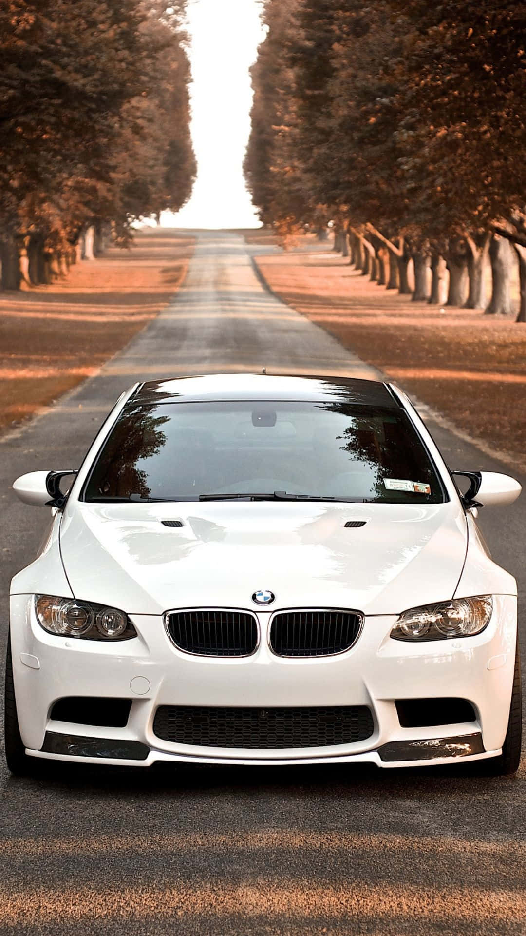 Et hvidt BMW M3-bil er parkeret på en vej. Wallpaper