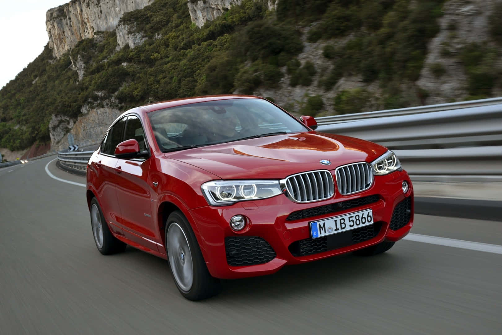 Sleek BMW X4 showcasing its striking design and powerful performance on an open road Wallpaper