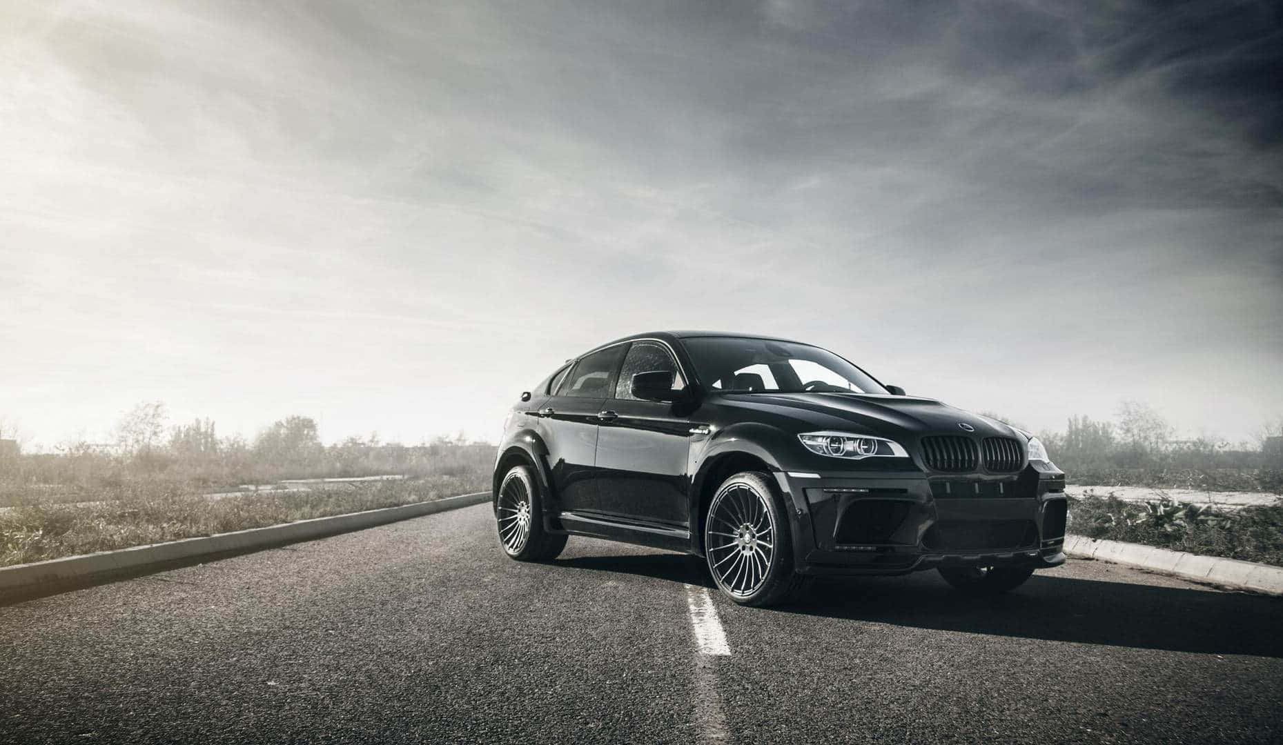 Sleek BMW X6 cruising on a scenic road Wallpaper