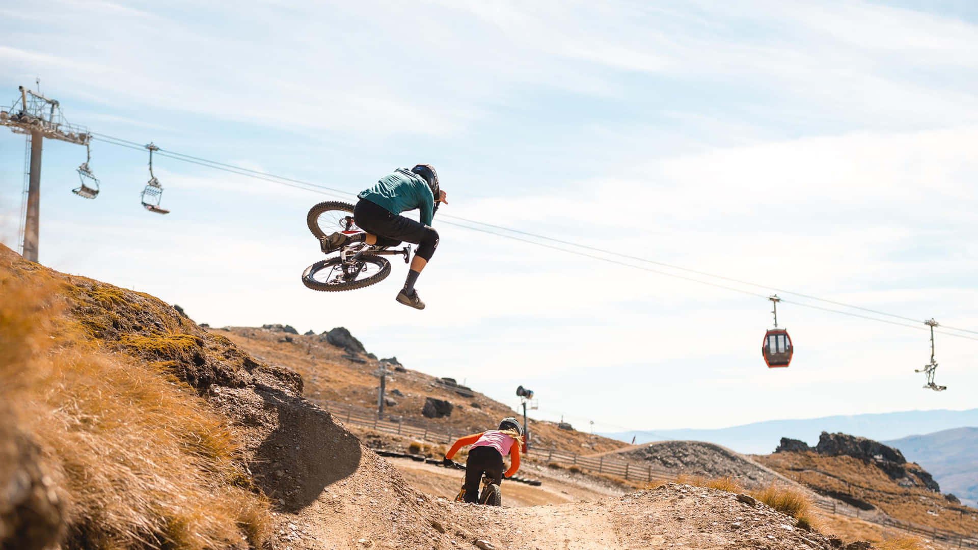 A Man Is Doing A Jump On A Mountain Bike Wallpaper