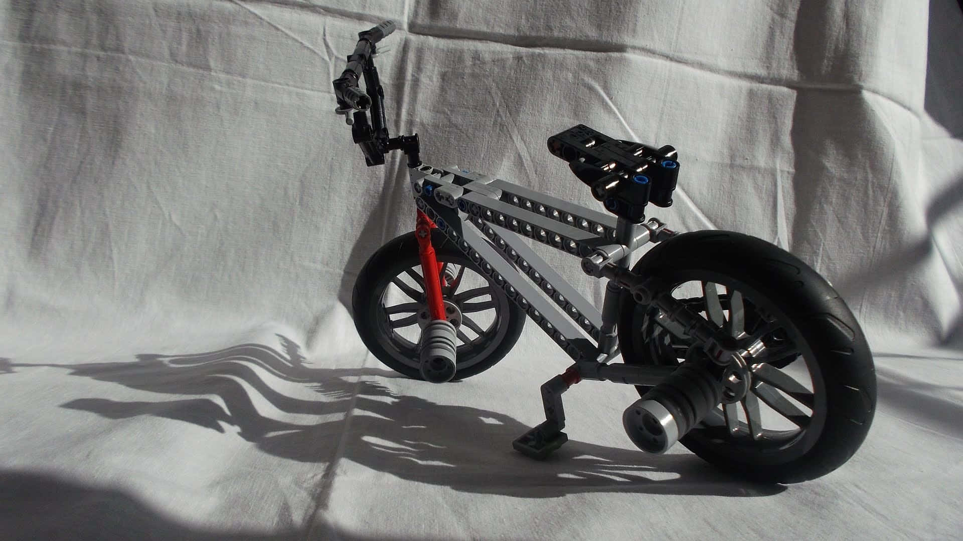 A Lego Bike On A White Cloth Wallpaper