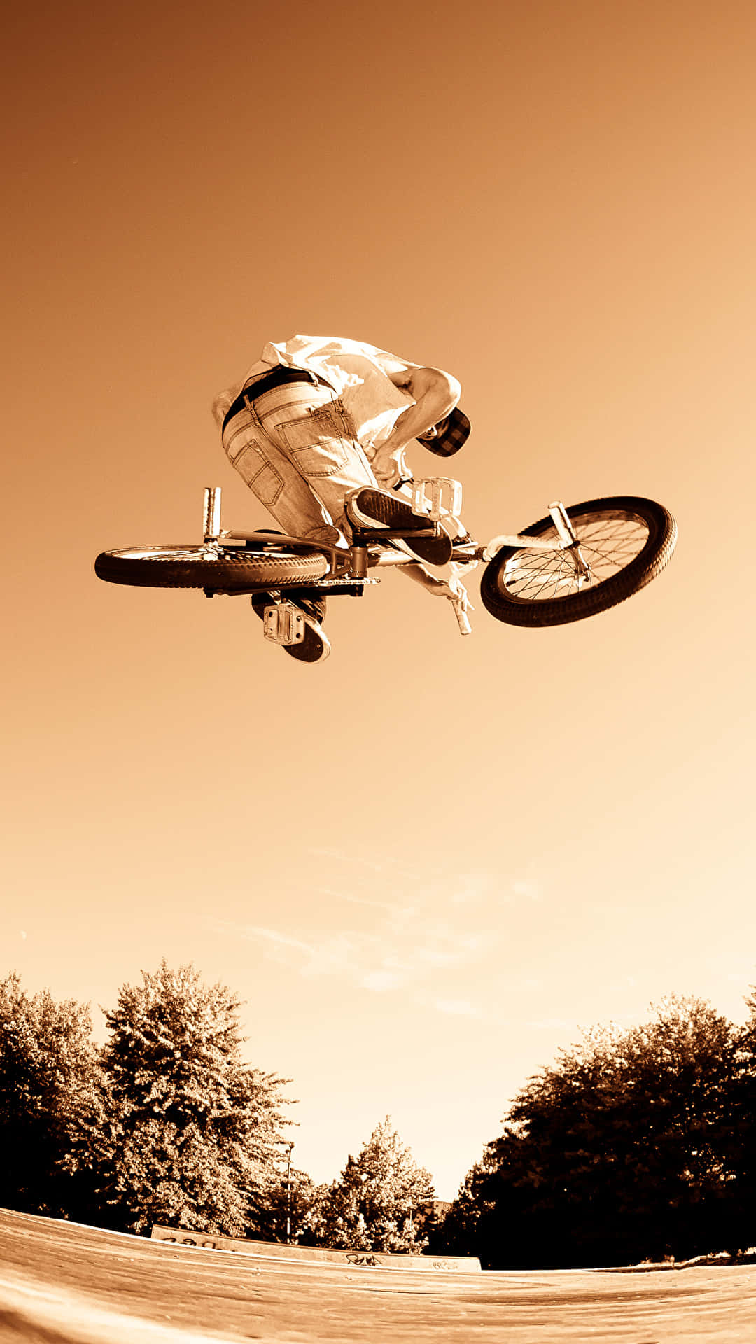 En person udfører et trick på en cykel i et surreelt baggrund Wallpaper