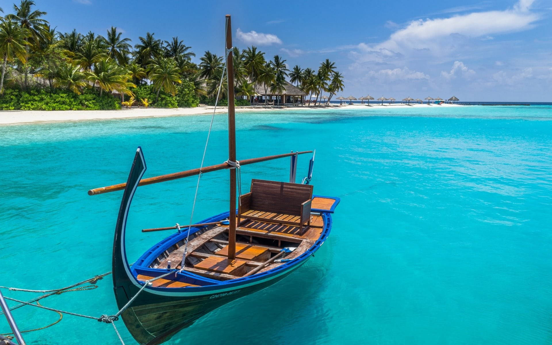 Tropical Serenity: A Boat on Azure Seas Wallpaper
