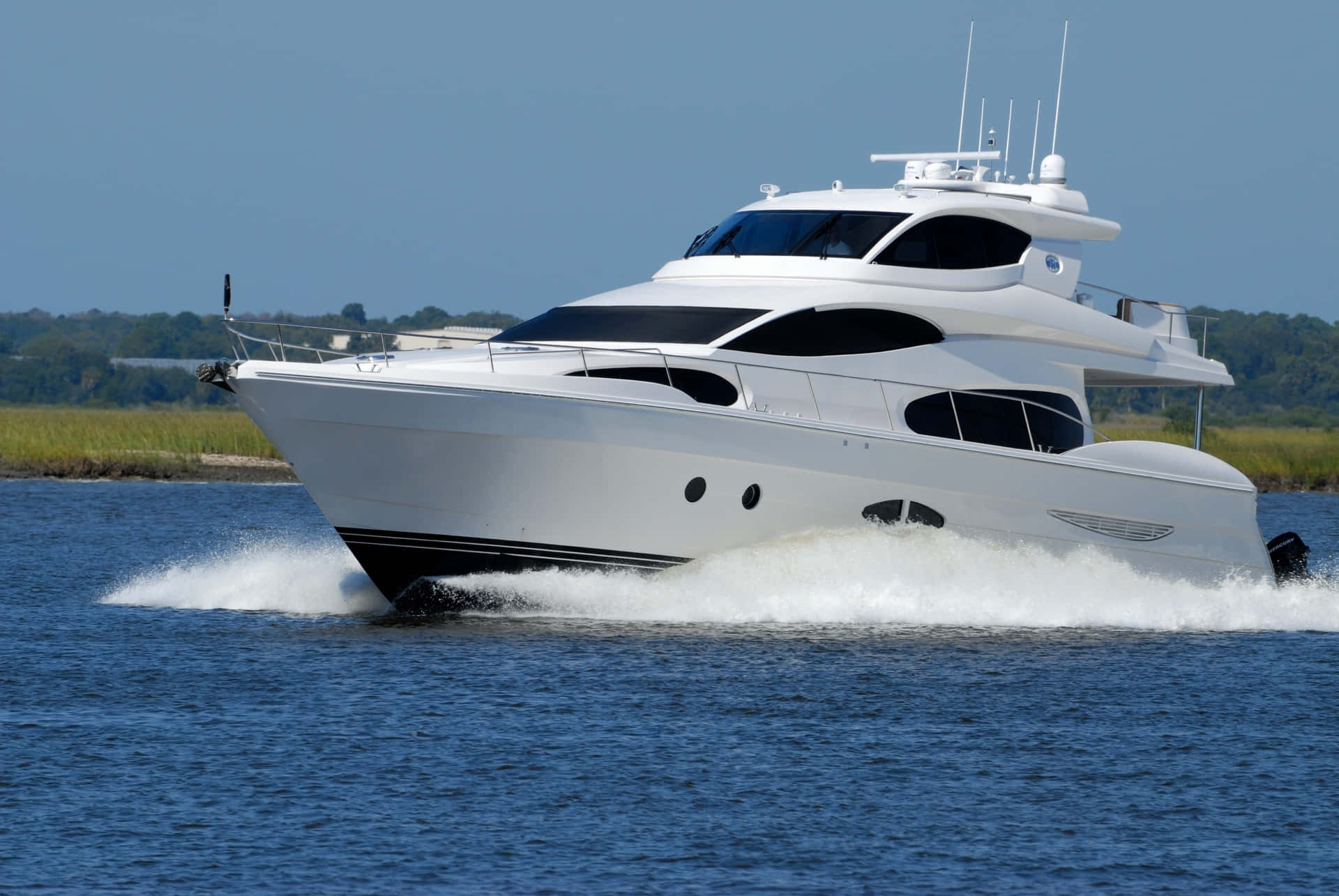 A White Motor Yacht Is Traveling Through The Water