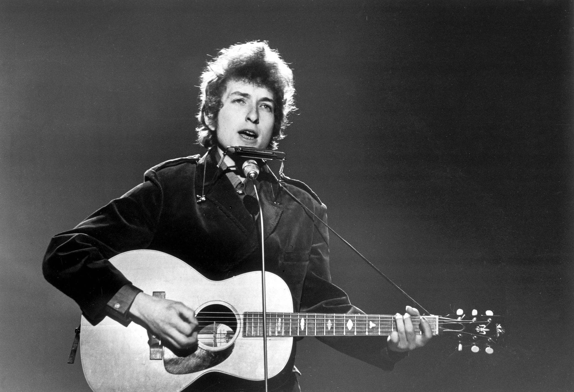 Legendary Music Icon Bob Dylan Strumming His Guitar Wallpaper