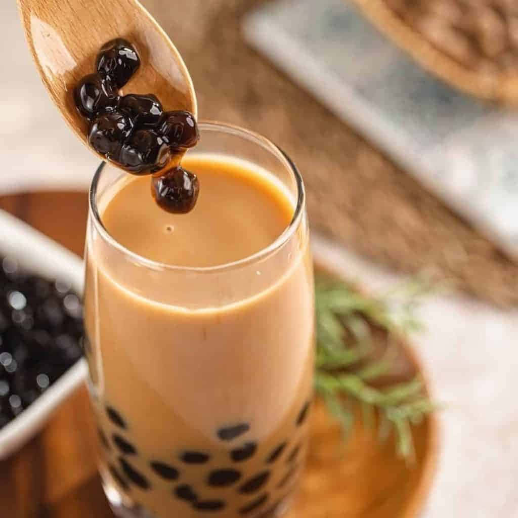 A Glass Of Bubble Tea With Blackberries On Top