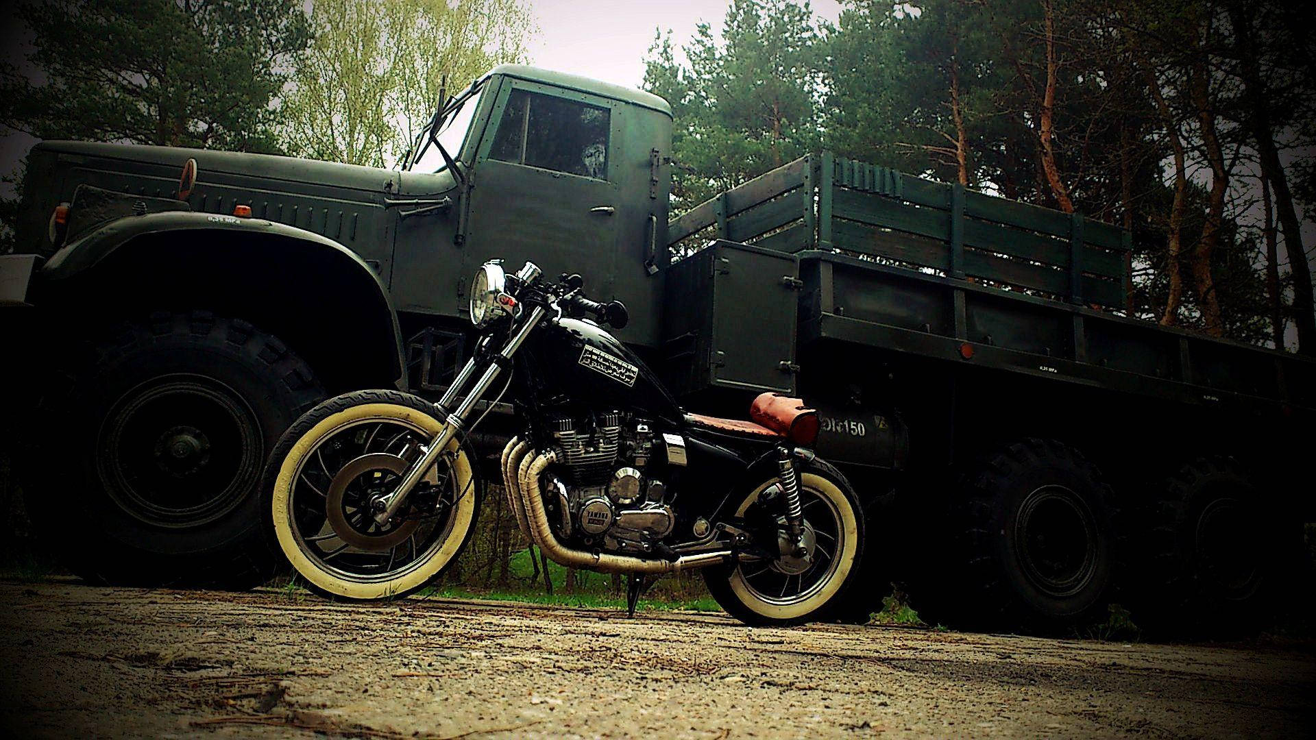 Bobber Motorcycle Ved Siden Af ​​en Army Truck på Vejen Wallpaper