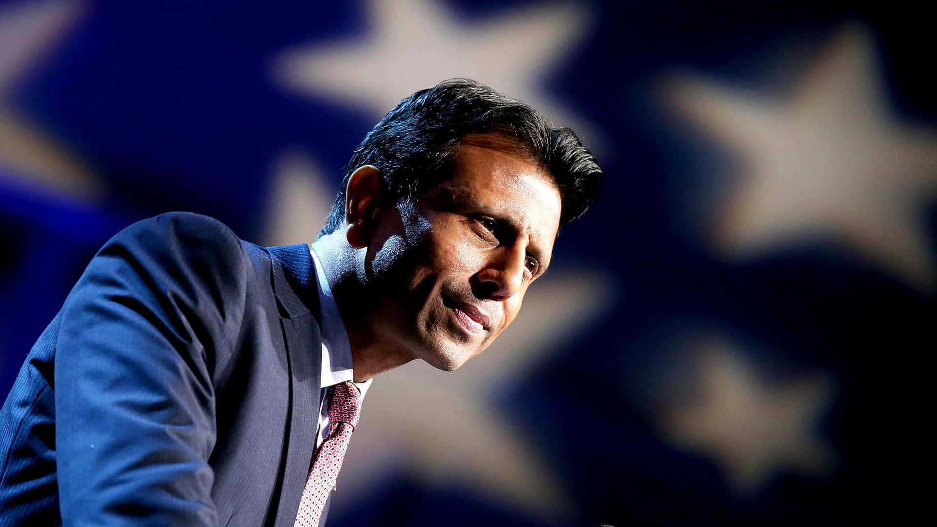 Bobby Jindal Standing Proudly With American Flag Wallpaper