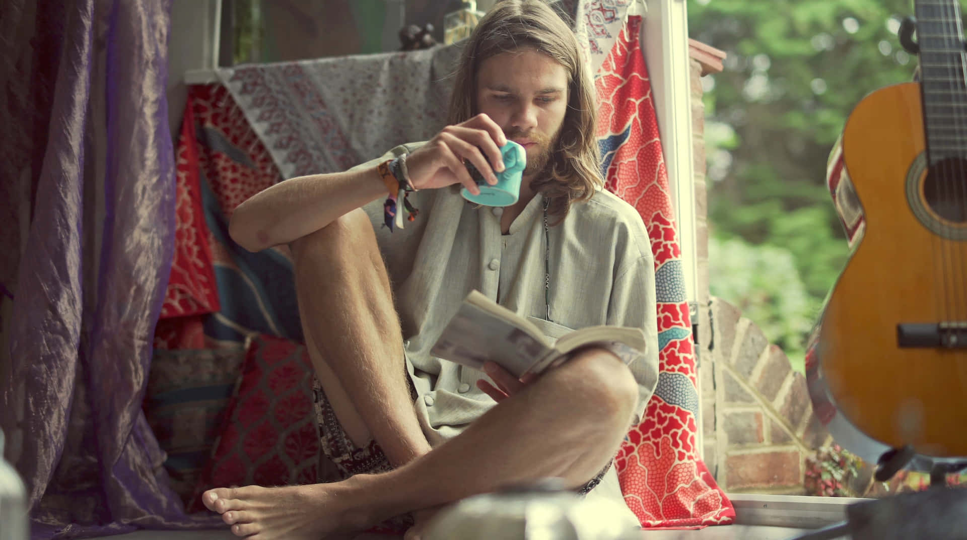 Boho Hippie Man Relaxingwith Bookand Tea Wallpaper