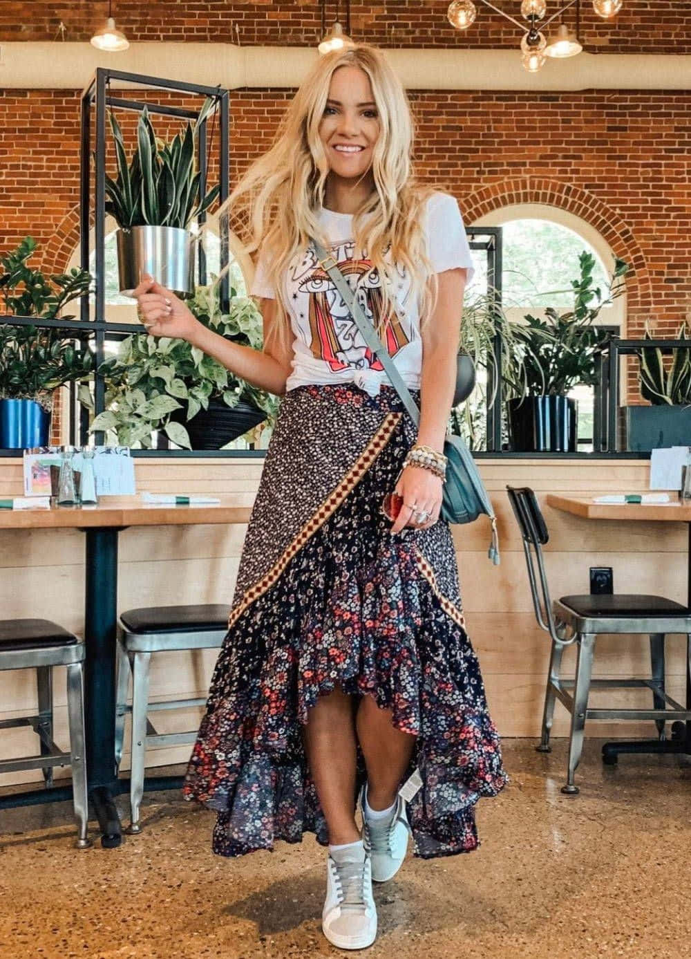 A Blonde Woman Wearing A Floral Skirt And A White T - Shirt