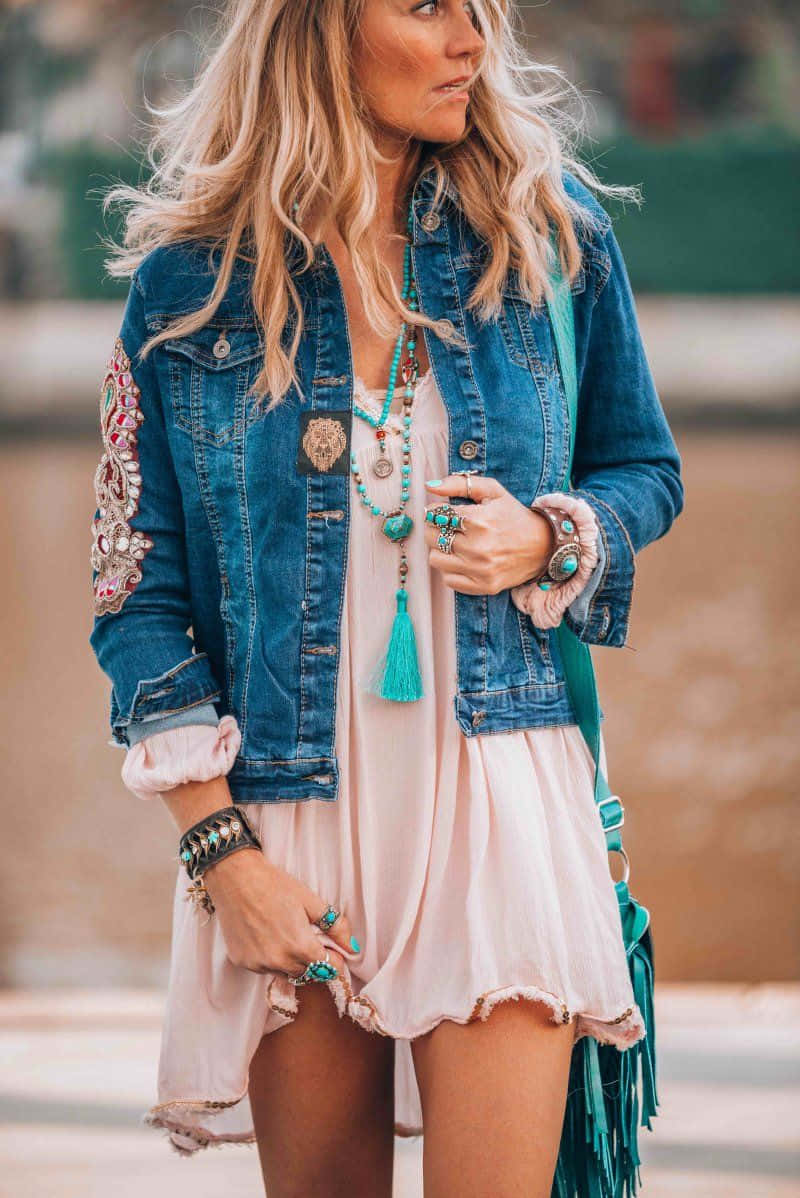 A Woman In A Blue Denim Jacket And A Turquoise Tassel Necklace
